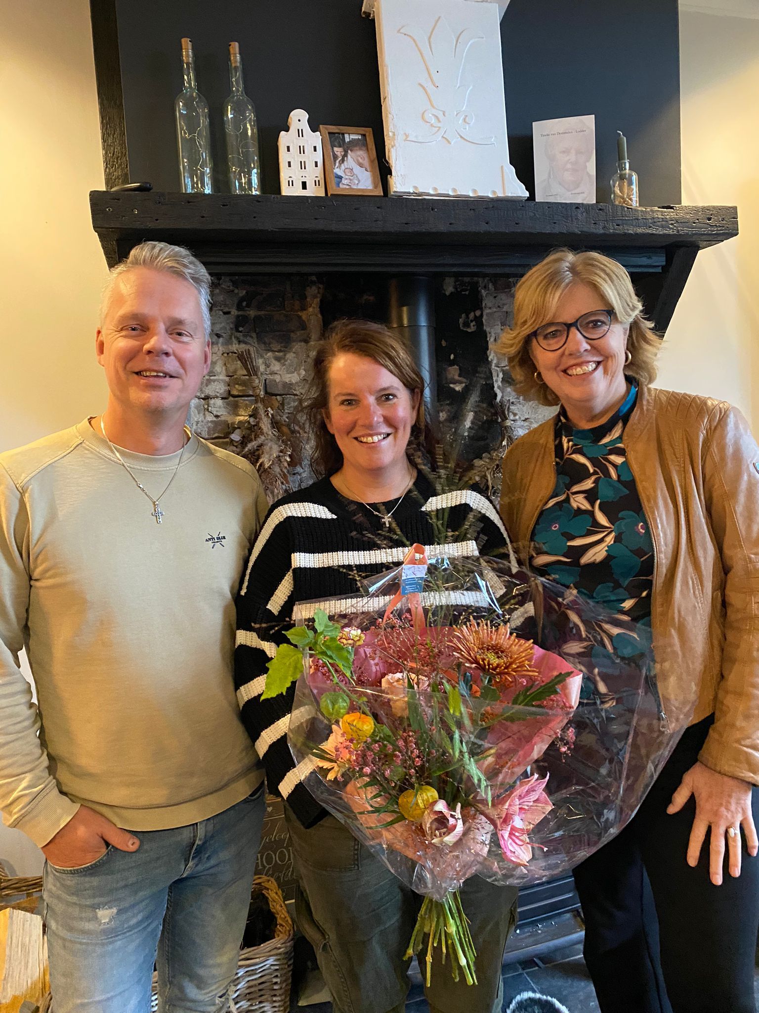 Wethouder Margreet de Deugd overhandigt bloemen aan Bert en Esther Vonk die een gezinshuis voor pleegkinderen hebben