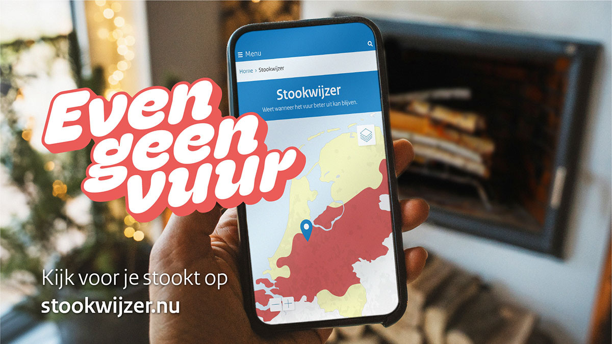 Foto van een hand met een telefoon waarop de Stookwijzer App geopend is. Daarnaast staat in tekst een verwijzing naar www.stookwijzer.nl voor meer informatie.